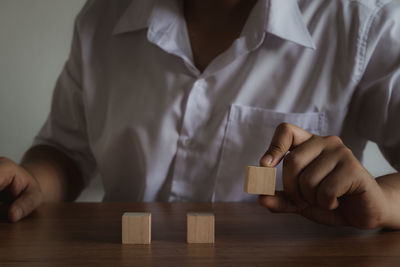 Midsection of man with toy on table