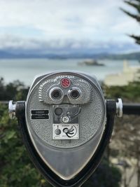 Close-up of coin-operated binoculars against sky