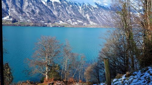 Scenic view of lake by mountains during winter