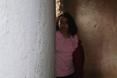Portrait of woman leaning on wall
