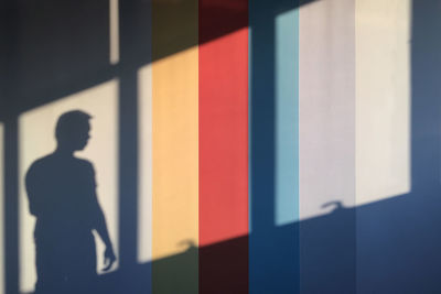 Silhouette man standing against multi colored shadow