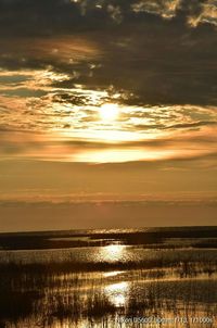 Scenic view of sea against dramatic sky during sunset