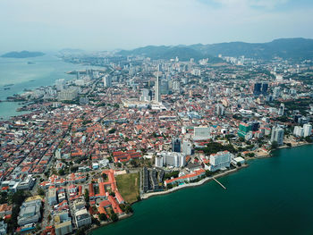 High angle view of townscape by sea against sky