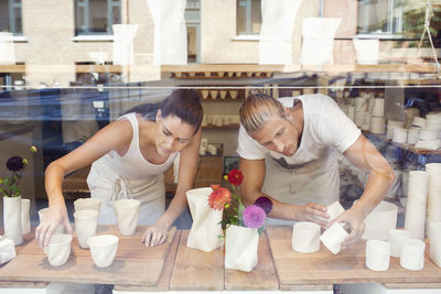 Workers arranging craft products for display in crockery workshop
