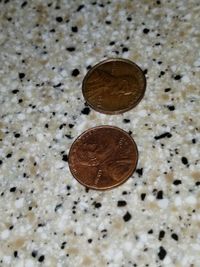 High angle view of coins on metal