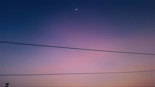 Low angle view of power lines against clear sky