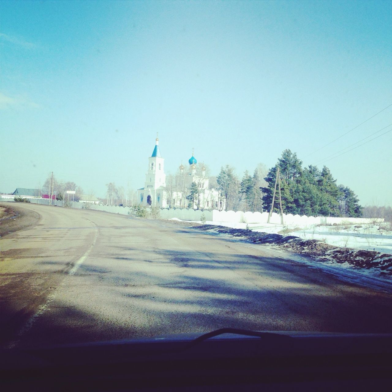 clear sky, blue, snow, copy space, winter, cold temperature, built structure, building exterior, architecture, road, season, tree, street, city, white color, day, transportation, travel destinations, outdoors, incidental people