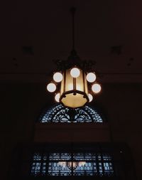 Low angle view of illuminated lamp hanging from ceiling
