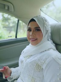 Portrait of bride sitting in car