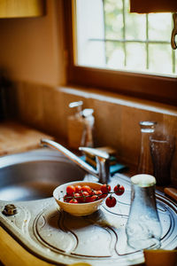 Tomatoes in bowl by sink at home