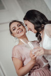 Bridesmaid and bride holding champagne flute