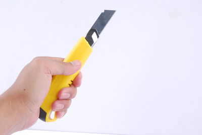 Close-up of person holding umbrella against white background