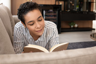 Portrait of young woman sitting on book