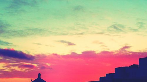 High section of building against cloudy sky at sunset