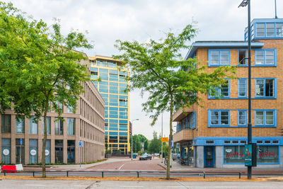 Residential building by street against sky