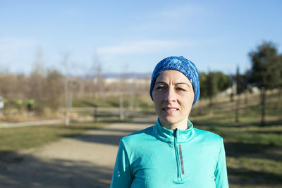 Portrait of smiling woman standing against blue sky