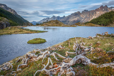 Scenic view of lake by mountains against sky