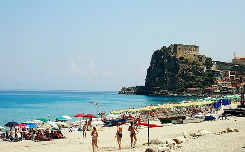 Panoramic view of people on beach against clear sky