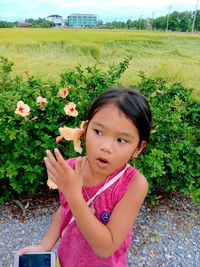 Portrait of cute girl on pink flowering plants