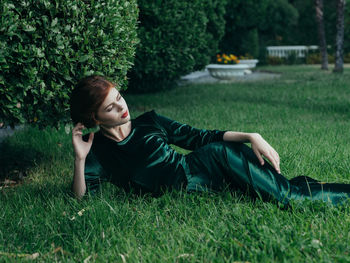 Young woman lying on grassy field