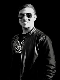 Portrait of young man against black background