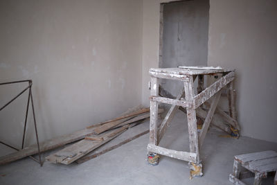 Abandoned chair on table against wall