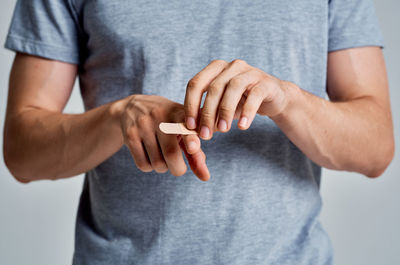 Midsection of man holding hands against white background