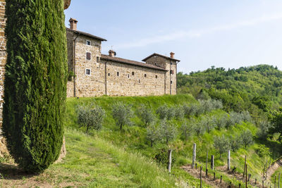 View of old building in field against sky