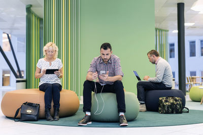 Businesspeople using technologies at modern office lobby