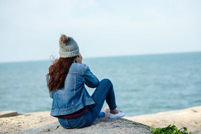 Rear view of woman looking at sea against sky