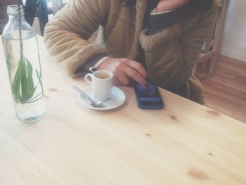 Midsection of woman holding coffee cup