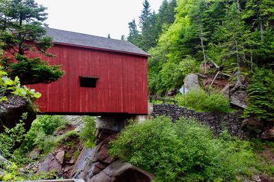 Built structure by trees against sky
