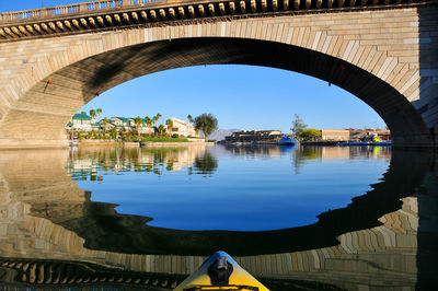 Arch bridge over river against sky