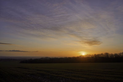 Scenic view of field against sky during sunset
