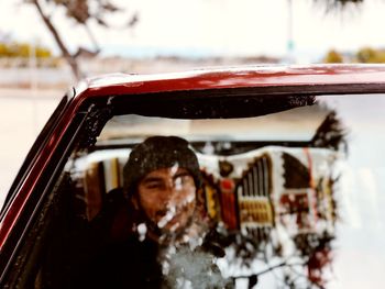 Young man in car seen through windshield