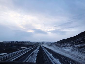 Empty road against sky during winter