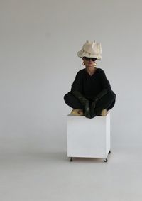 Portrait of woman wearing hat against white wall