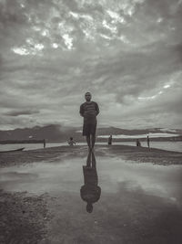 Man standing on beach against sky