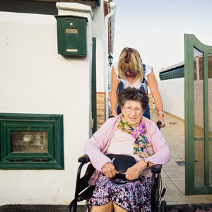 Portrait of smiling woman standing against building