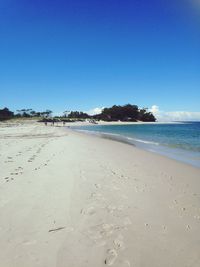 Scenic view of beach against clear blue sky