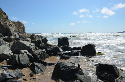 Rocks on beach against sky