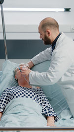 Side view of doctor examining patient in hospital