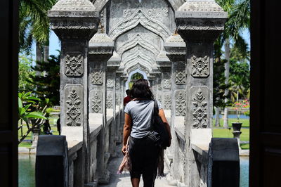 Rear view of woman standing in front of building