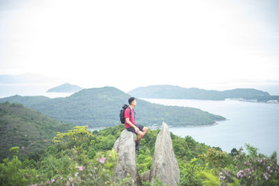 Young woman looking at mountains against sky