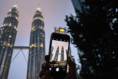 Low angle view of communications tower in city