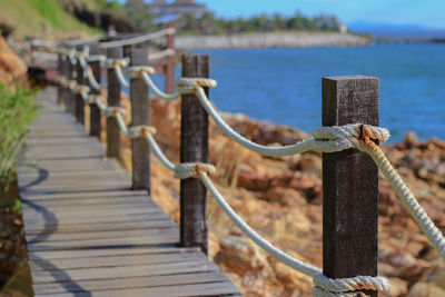 Close-up of wooden fence by railing