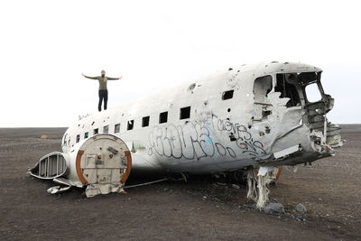 Abandoned airplane on airport runway against sky