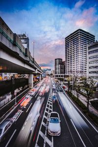 Traffic on road in city against sky