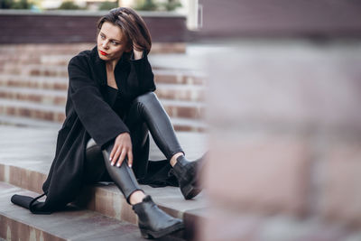 Full length of woman sitting on floor