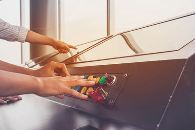 Cropped image of people pressing push buttons on machinery